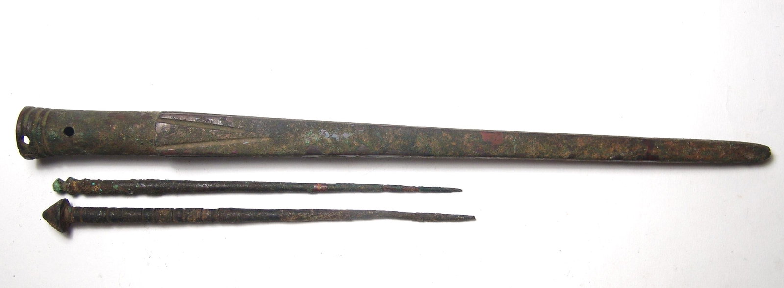 A Near Eastern spike and pair of cloak pin: A Near Eastern spike and pair of cloak pins. Lot includes a pair of Near Eastern bronze cloak pins, c. 1200 - 600 BC, each with incised decoration, the larger with domed terminal and central toggle ho