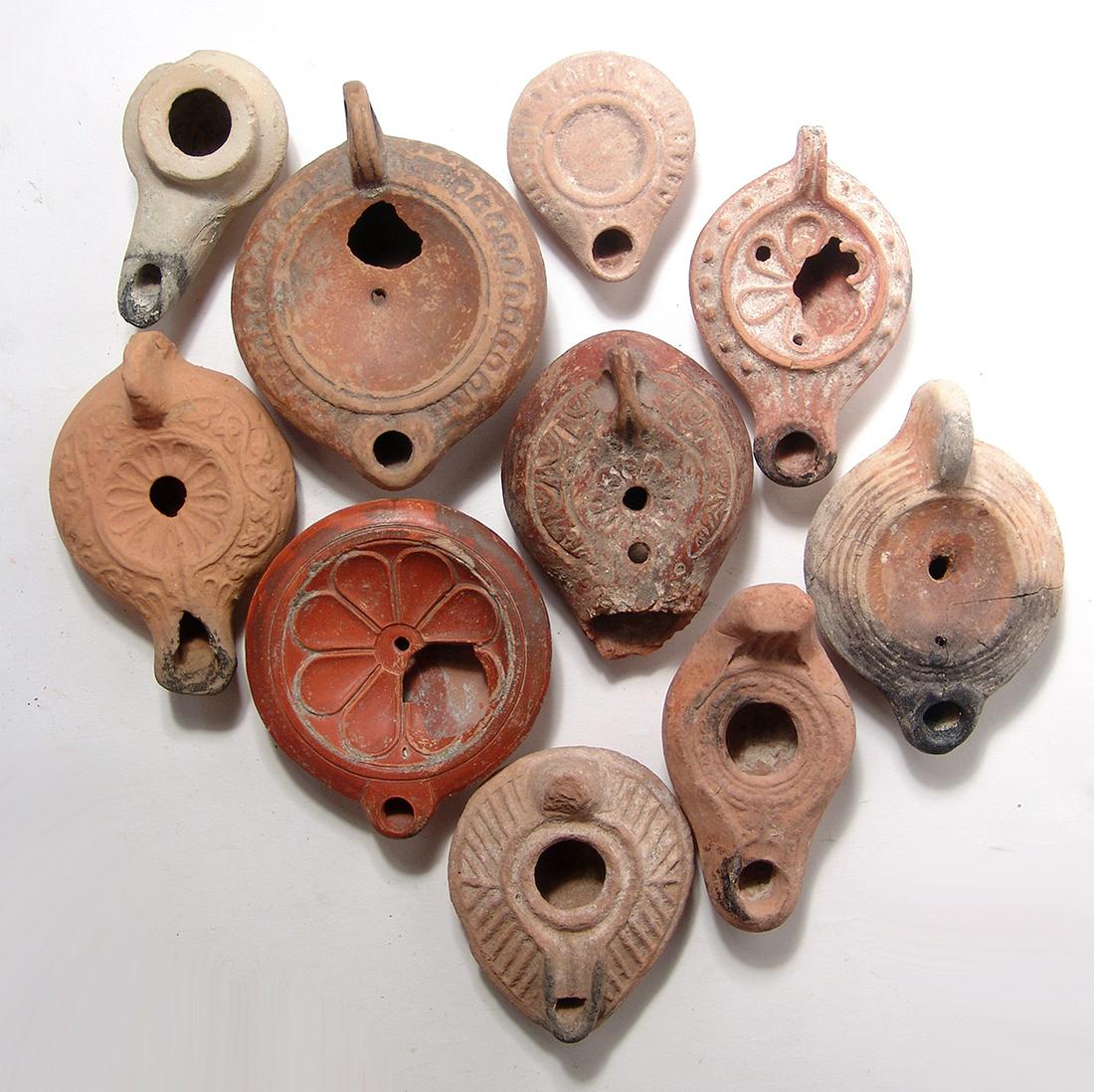 A lot of 10 Roman and Byzantine ceramic lamps: A lot of 10 Roman and Byzantine ceramic lamps of various types. Lot includes several Roman types including a pair of discus lamps, one with a rosette, 1st - 2nd Century AD, and several from the Levant