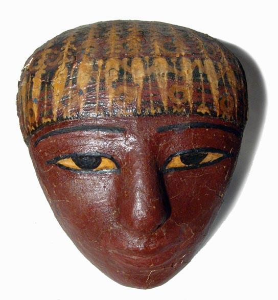 Choice Egyptian cartonnage mask from sarcophagus: A choice Late Period cartonnage "mask" from a sarcophagus, c. 664 – 332 BC, with deep red-brown color, part of the headdress in golden yellow with black and white cosmetic details. The eyes are very