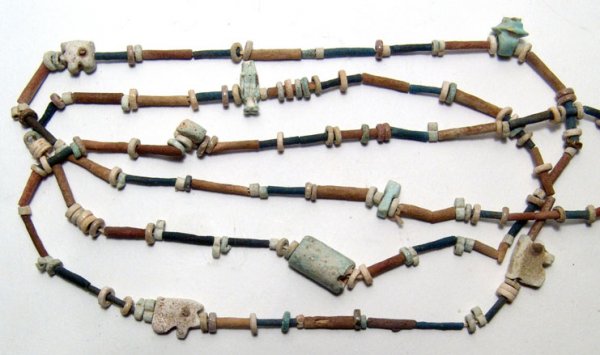 Long necklace of multicolored faience beads: A long necklace comprised of multicolored faience beads, Late Period, c. 664 – 30 BC, some tubular and others single and double discs. Strung amongst the beads are 8 amulets, some fragmentary, inclu