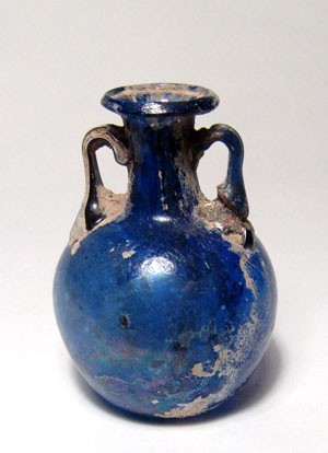 Very nice Roman cobalt blue glass bottle: A very nice cobalt blue glass bottle, Roman, 1st Century AD, with rounded body and concave base, short cylindrical neck and flaring and inward-folded rim. Intact, tiny hole one side of the body. Beaut