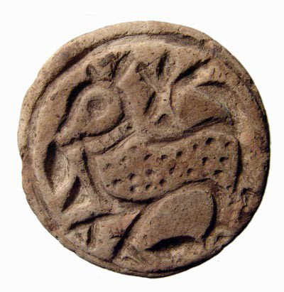 A circular terracotta stamp seal, Central Asia: A circular terracotta stamp seal, Central Asia, c. 1st Millennium BC, depicting a stylized goat, with spotted body and wearing a collar. Various symbols are within the fields and a small applied handl