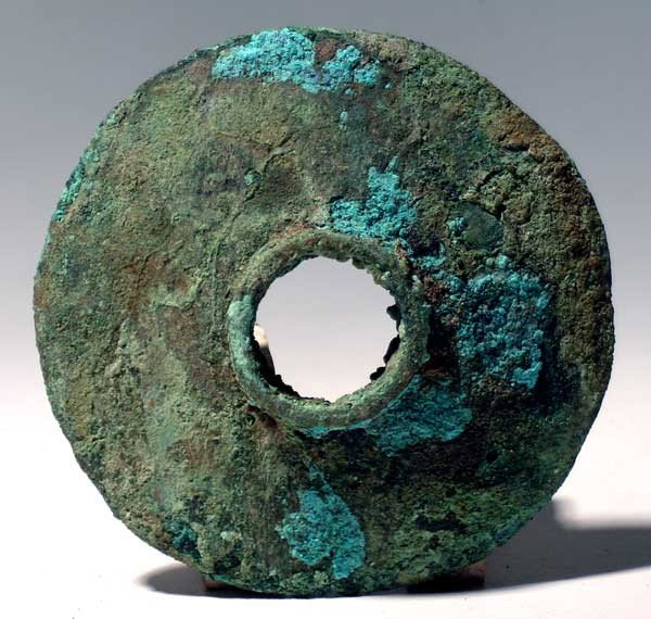 Excellent Vicus copper mace head from Peru: An excellent Vicus copper mace head from Peru, c. 200 BC - AD 200. This choice example is 4" in diameter, with a 1/2" center sleeve where it was attached to the handle. It has a convex shape and is in