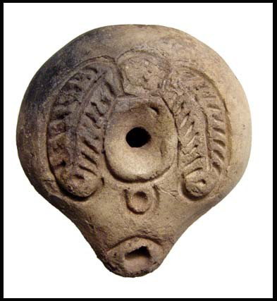 Attractive Egyptian frog lamp: An attractive Egyptian frog lamp, 3rd-4th Century AD. Mouldmade and kidney-shaped with inward sloping rim and short tapered nozzle. On shoulder, a high relief of two palm branches, connected by a shor