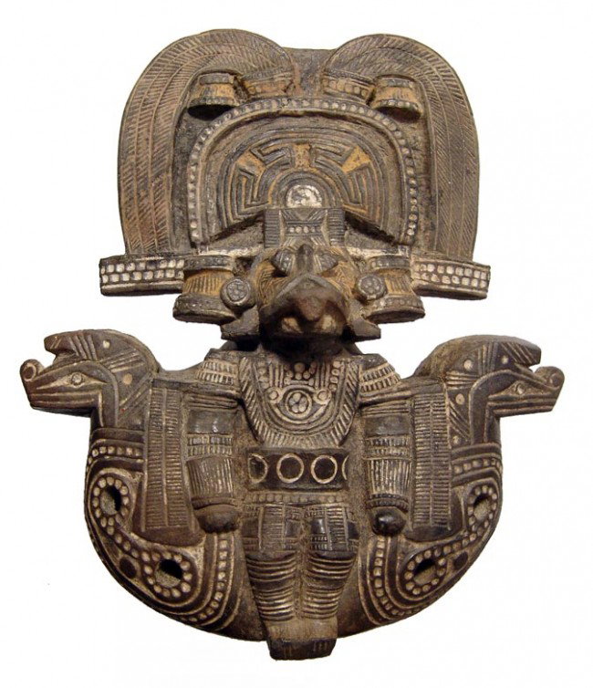 Beautiful Tairona ocarina in the form of a deity: A beautiful Tairona ocarina in the form of a deity, Colombia, c. AD 1000-1500, he sits on a seat with two serpent heads, wearing an elaborate headdress and costume. Minor repair to top left side of he