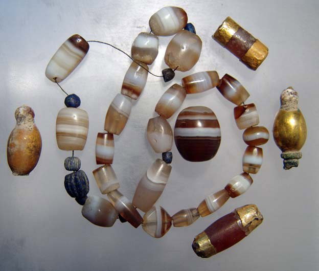 Gold and agate beads, Late Roman-Byzantine: A group of gold and agate beads, Late Roman-Byzantine, c. 4th - 7th Century BC, composed of mainly brown and white agate beads, two of them with gilded caps and two entirely gilded. Largest bead measu