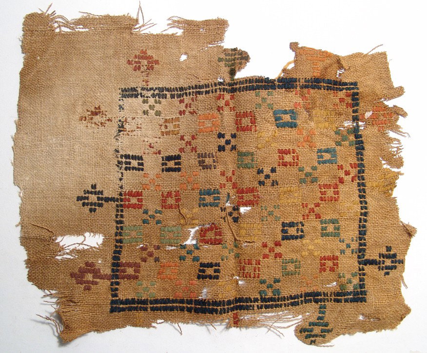 Coptic textile panel with geometric decoration: A rectangular Coptic textile panel with geometric decoration, Egypt, 7th - 9th Century AD, linen and wool. The panel is coarsely woven with colorful X's and squares within a large square border, addit
