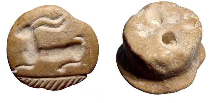 Marble stamp seal wit horned goat, Syria: An attractive crme marble stamp seal wit horned goat, Syria, late 2nd Millennium BC, nicely carved with a palm frond below. Intact with suspension holes drilled into the back. W: 21mm. Ex Canadian pri