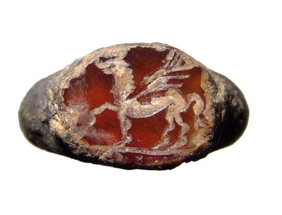 Roman bronze ring, intaglio depicting Pegasus: A Roman bronze ring with intaglio depicting Pegasus, c. 1st - 3rd Century AD, the carnelian stone with deep orange color. The ring was originally silvered, with traces of the metal within the encrusta