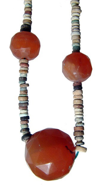 Egyptian faience and carnelian bead necklace: A necklace composed of Egyptian faience disk beads and antique carnelian beads. The faience beads date from the Late Period, c. 664 - 30 BC, mostly in crmes and browns. The antique carnelian beads are