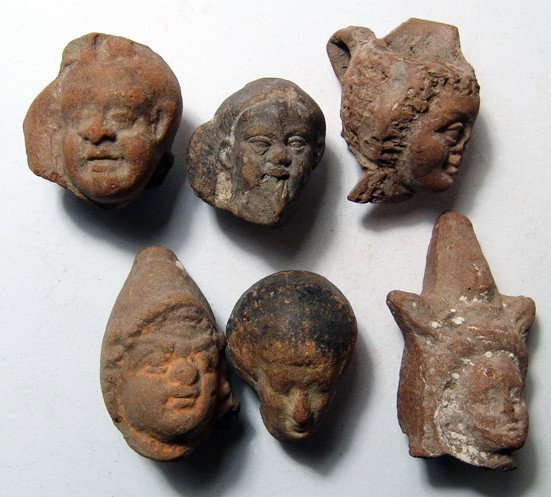 6 terracotta head from Graeco-Roman Egypt: A nice group of 6 terracotta head from Graeco-Roman Egypt, c. 2nd Century BC/AD. Lot includes 4 heads of Harpokrates, one of the goddess Isis and another of a fashionable lady. Largest measures 2" (5.