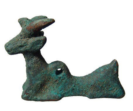 Persia. Luristan bronze reclining horn goat: A Luristan bronze reclining horn goat, Western Iran, c. 1000 - 800 BC, nicely formed with a bird seated on its head between the horns. A groove runs along the base of the figure, perhaps for a whetsto