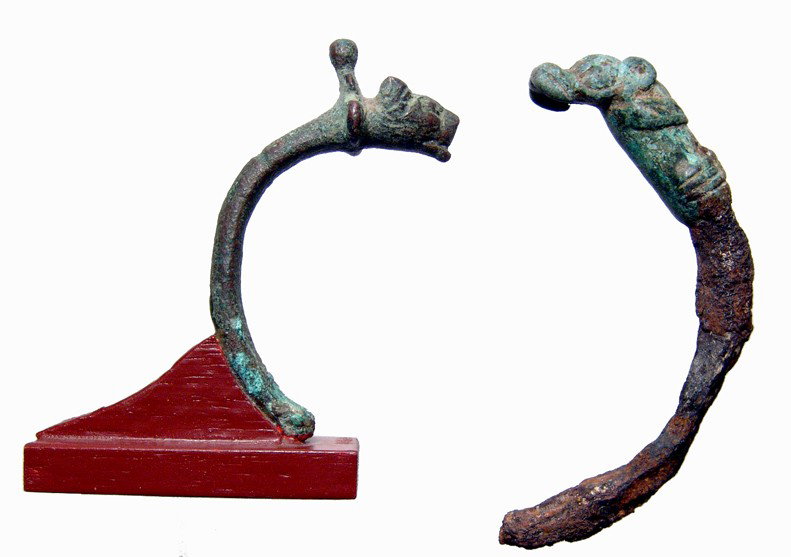 2 bronze bracelet terminals: feline heads: A pair of bronze bracelet terminals in the form of feline heads. The first is from Western Iran, 1st Millennium BC, with part of the iron bracelet, the lovely style characteristic of Luristan. Cf. Moo