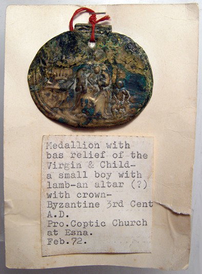 Byzantine bronze medallion, Virgin with baby: A Byzantine bronze oval medallion depicting the Virgin with baby in lap, c. 5th - 7th Century AD, a small boy with a lamb to her left, a crown on square table to her right. Some light corrosion and en