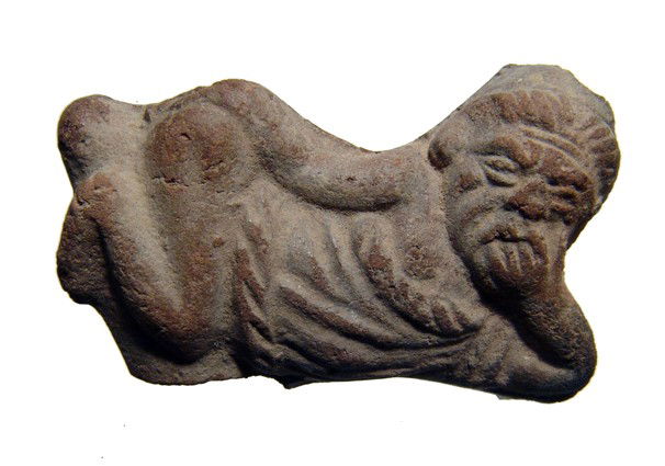 Ptolemaic erotic figure of an old man: A terracotta erotic figure of an old man, Ptolemaic Period, c. 2nd - 1st Century BC, laying on his side, hand to his face, without his pants and revealing enlarged phallus. His facial features are nic