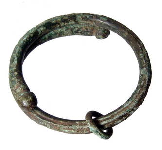 Luristan bronze bracelet with domed terminals: A Luristan bronze bracelet with domed terminals, Western Iran, c. 1st Millennium BC, the body round and even with grooves evenly spaced around the outside. Intact with some light pitting. A sliding