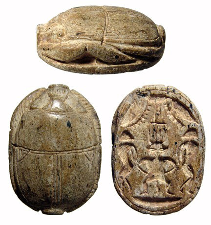 Large steatite New Kingdom scarab, Egypt: A large steatite New Kingdom scarab, c. 1570 - 1075 BC, with a central figure of Bes flanked by bound Libyan captives, a winged vulture above. Intact and without glaze. 38 x 27mm. Ex Cecil Best collec