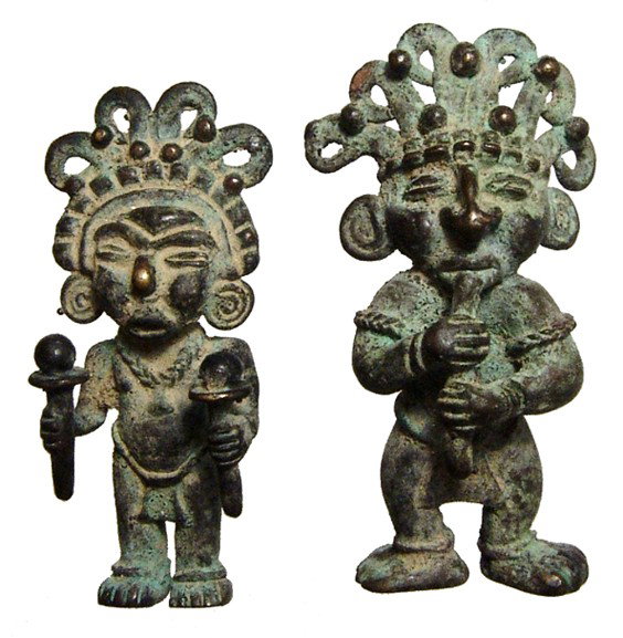 Pair of Tolima copper pendants, Colombia: A pair of Tolima copper pendants, Colombia, c. AD 1000 - 1500, each wearing an elaborate headdress, jewelry and a lion cloth. One holds rattles in each hand and the other plays a wind instrument. Each