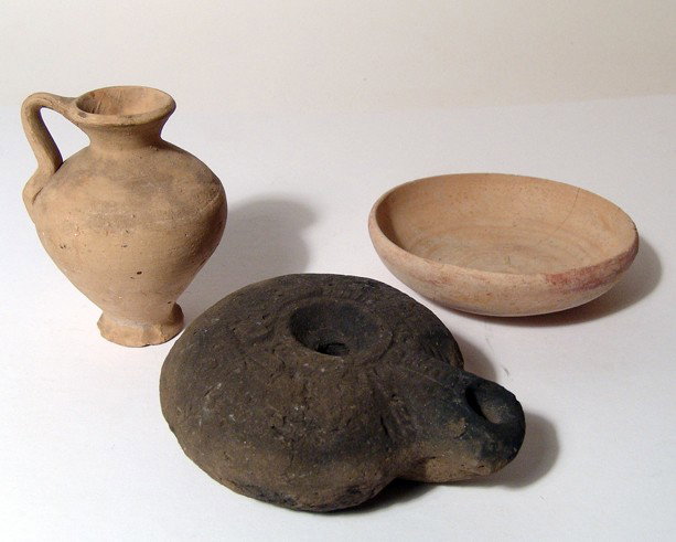 3 Roman pottery items: frog lamp, juglet, bowl: A trio of Roman pottery items. Lot includes an Egyptian "frog" lamp, c. 4th - 5th Century AD, with characteristic kidney shape and stylized frog motif on base, L: 4 1/4" (10.8 cm). Roughness and carbo