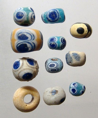 Lot of Eastern Mediterranean glass 'eye' beads: A lot of 11 Eastern Mediterranean glass 'eye' beads, c. 6th - 3rd Century BC. An attractive group in yellow or blue green with blue and white 'eyes', each intact with good color. Largest measures 12mm