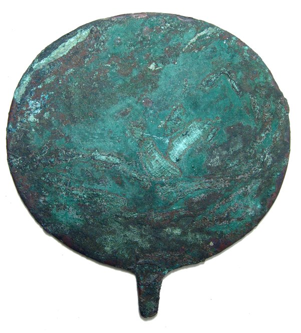 Egyptian circular copper mirror, Old Kingdom: An Egyptian circular copper mirror, Old Kingdom, IV - VI Dynasty, c. 2625 - 2170 BC, with short tang for fastening to a handle. Intact with some of the burial clothing preserved on the surface. 4 7/8"