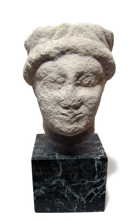 Attractive Roman limestone head of a youth: An attractive Roman limestone head of a youth, c. 4th - 5th Century AD, with handsome features and wearing laurel wreath. Some light overall wear. H: 5" (12.7 cm). Mounted on a stone base. Ex Northern