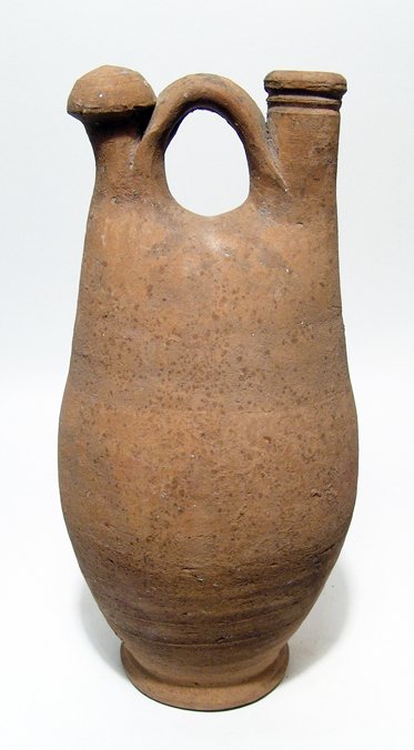 Large Late Roman / Byzantine ceramic jug: A large Late Roman / Byzantine ceramic jug, c. 5th - 6th Century AD, with central handle between the vertical spout and a capped knob, the ring foot lightly flared. The spout is constricted at the bas