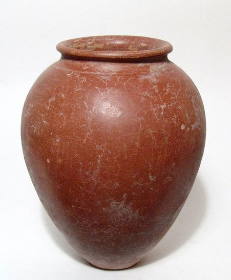 Predynastic burnished red-ware jar, Naqada IIc-d: A choice Predynastic burnished red-ware jar, Naqada IIc-d, c. 3650 - 3300 BC, of elegant form, a ridge wear the rim was attached to the shoulder, the base flat. H: 8 1/2" (21.6 cm). Intact with light
