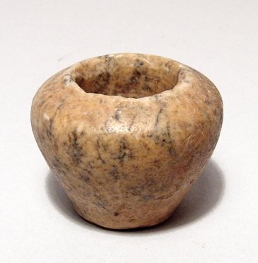 Egyptian stone kohl jar, Old Kingdom: An Egyptian stone kohl jar, Old Kingdom, Dynasty IV - VI, c. 2625 - 2170 BC, of breccia, the wide shoulders narrowing to a flat base, the inside drilled with wide opening, some chipping around the edg