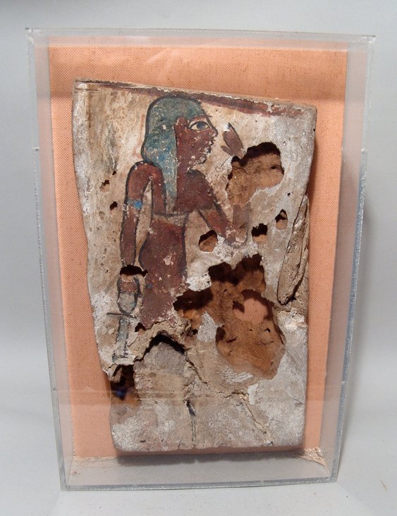 Egyptian painted wood panel, Ex Alex Malloy 1980: An Egyptian painted wood panel depicting a kneeling goddess, Late Period, c. 664 - 30 BC, wearing a close-fitting dress and armlets, her breast exposed, her left hand held to her face and holding an a