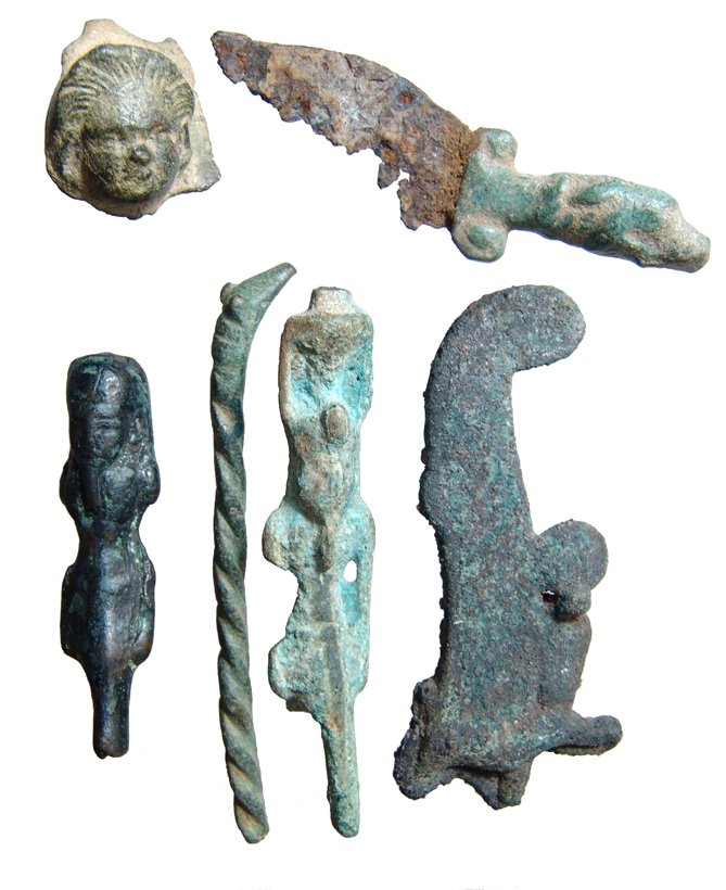 Lot of 6 Egyptian bronze items: A lot of 6 Egyptian bronze items. Lot includes a bronze feather from a headdress, such as an Atef crown of Osiris, showing the ram's horn and erect cobra (uraeus), Late Period, c. 664 - 343 BC. H: 3 1