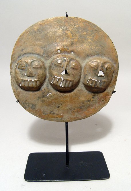 Circular gilded copper Narino jaguar pectoral: Pre Columbian. A circular gilded copper Narino jaguar pectoral, Colombia, c. AD 1000 - 1500, with three heads of the feline, rather stylized, across the center. Dia: 5 3/8" (13.7 cm). Some minor casti