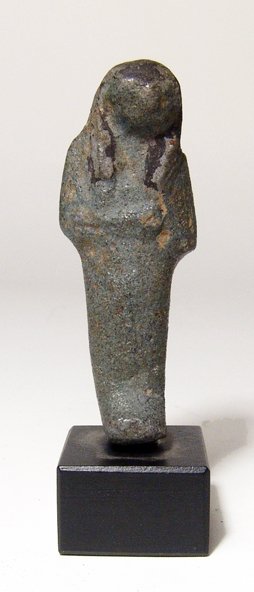 Egyptian bi-color faience ushabti, 3rd Int. Period: An Egyptian bi-color faience ushabti, 3rd Intermediate Period, c. 1075 - 664 BC, the facial features resembling Horus. L: 2 5/8" (6.7 cm). Intact, glaze now a greyish black color. Mounted. Ex Harvey F