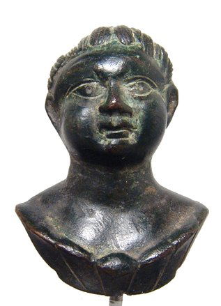 Choice Roman bronze applique bust of a youth: A choice Roman bronze applique bust of a youth, 1st Century AD, with handsome features, his well-defined locks of hair framing the top of his face. His checks are round and full, his lips purses and h