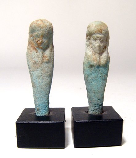 Lot of 2 Egyptian faience ushabtis: A lot of 2 Egyptian faience ushabtis, Ptolemaic, c. 305 - 30 BC, both frontally molded and each mummiform, wearing tripartite headdress, arms folded across chest, hands holding implements. H: 5 1/8" (