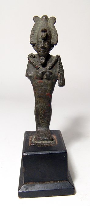 Egyptian bronze figure of Osiris, Late Period: An Egyptian bronze figure of Osiris, Late Period, c. 664 - 332 BC, mummiform, wearing atef crown with uraeus and false beard, arms folded across chest, hands holding a crook and flail. H: 4 1/8" (10.4