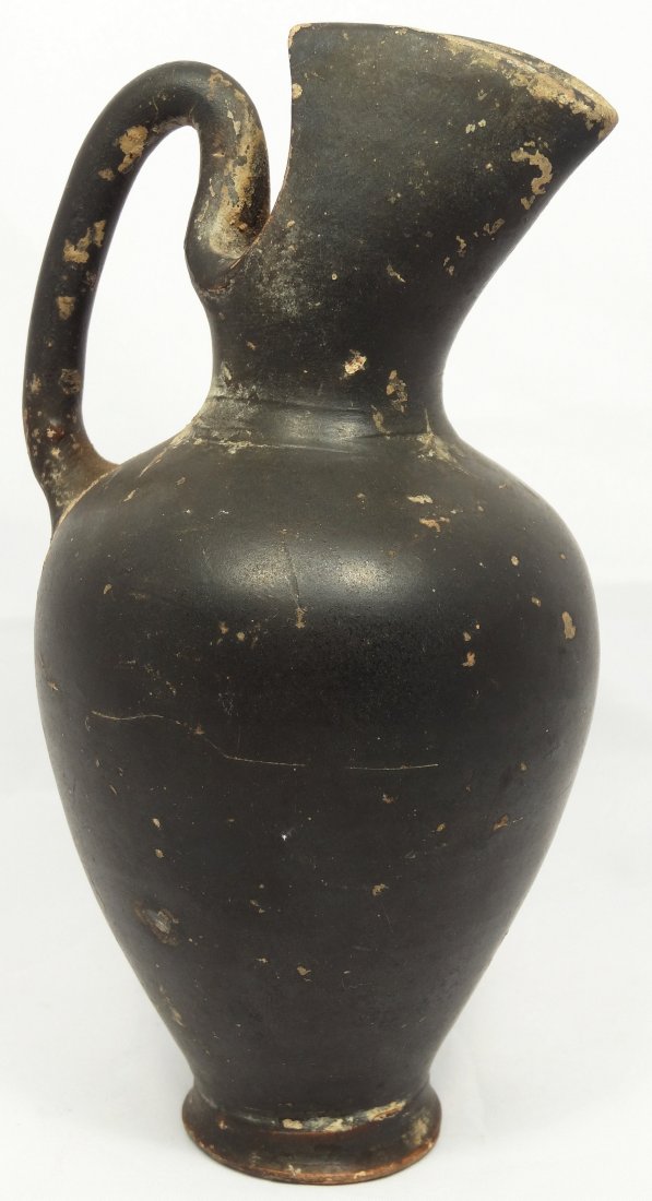 Etruscan pouring vessel of a scarcer type: A one handled Etruscan pouring vessel of a scarcer type, c. 5th-3rd Century BC, H: 14 cm. The narrow spout would allow for pouring in smaller increments, so this was probably used for more expensive l