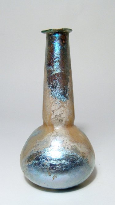 A beautiful Roman tall necked bottle: A beautiful Roman tall necked bottle, 1st - 2nd Century AD, with squat body and tall cylindrical neck, the mouth flattened with inward folded rim. H: 6 1/4" (15.8 cm). Intact with lovely silver-blue i