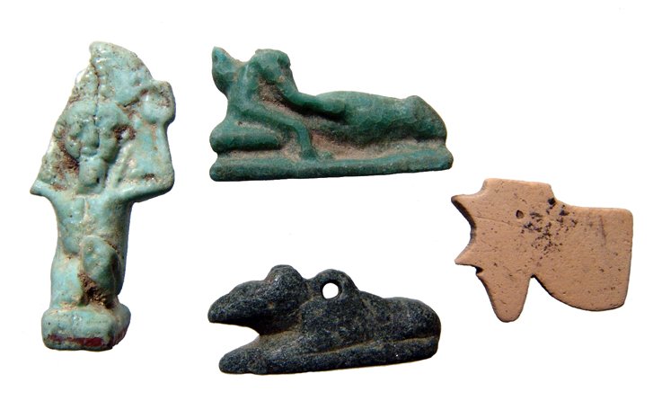 Lot of 4 Egyptian stone and faience amulets, Late Perio: A lot of 4 Egyptian stone and faience amulets, Late Period, c. 64 - 30 BC, including a black steatite amulet of an ichneumon, L: 25mm, a blue-green faience ithyphallic dwarf with enormous phallus, L: