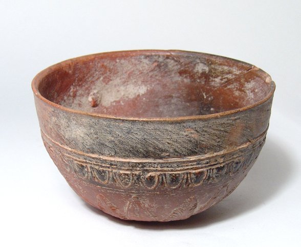 A relief molded red-ware Megarian bowl: A relief molded red-ware Megarian bowl, Hellenistic, c. 225 - 175 BC, the base with central medallion containing Nike driving a biga of horses surrounded by alternating palmettes and petals, an ovolo 