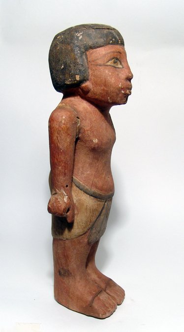 Ancient Egyptian style carved wooden bearer: An Ancient Egyptian Style Carved Wooden Figure of a Bearer Wearing a Knotted Skirt w/ Original Paint, H: 14" (40.5 cm). Some age cracks and loss of pigment. Ex New York City private collection.