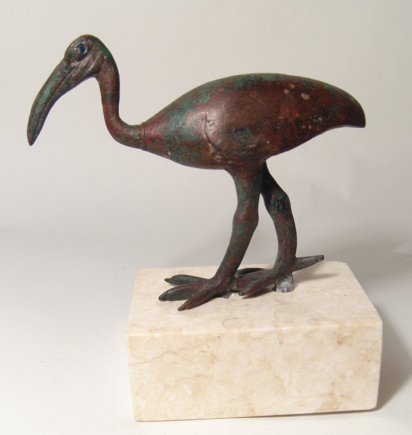 Egyptian Bronze Ibis With Gold & Blue Glass Eyes: An Egyptian bronze ibis with gold and blue glass eyes, Late Period, c. 664 - 30 BC, depicted standing with left foot forward, head nicely detailed. H: 8 7/8" (22.4 cm); L: 6 1/2" (15.8 cm). Intact, li