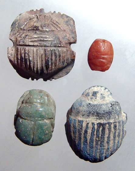 A lot of 4 Egyptian Stone Scarabs: A lot of 4 Egyptian stone scarabs. The first is a Late Period rhyolite example with flared legs and incised lines on the elytra. 30 x 19mm. The second a small New Kingdom carnelian example with neatly