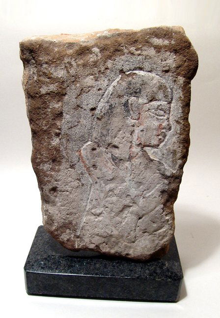 A sand stone relief depicting a male figure: A sand stone relief depicting a male figure, Late Period, c. 664 - 30 BC, a priest perhaps, his arms raised in adoration. Carved with remains of dressing and traces of pigment. 10 7/8" x 7 7/8" x 3 3/