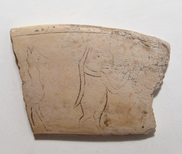 A fragment from an Egyptian magic wand: A fragment from an Egyptian magic wand, Middle Kingdom, c. 2024 - 1700 BC, with an incised image of the goddess Taweret wielding a knife, the forepart of an animal behind. Light deposits and very rare