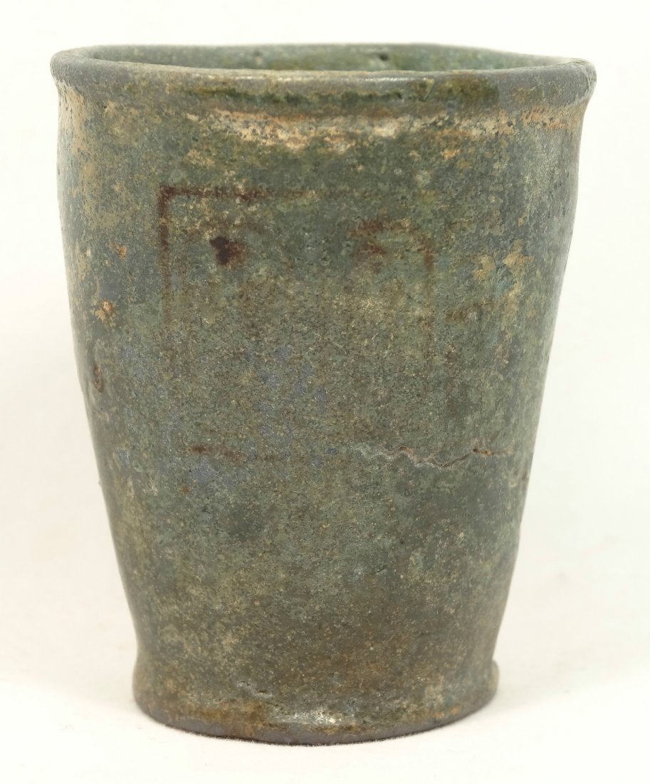 Faience offering cup, Ramesside Period Egypt: An Egyptian blue glazed faience offering cup, Ramesside Period, 19th Dynasty, c. 1320-1200 BC. Has a very worn royal cartouche on the body of the cup, H: 1 7/8 in (4.9cm), D: 1 3/5 in (4.1cm). Ex Coll