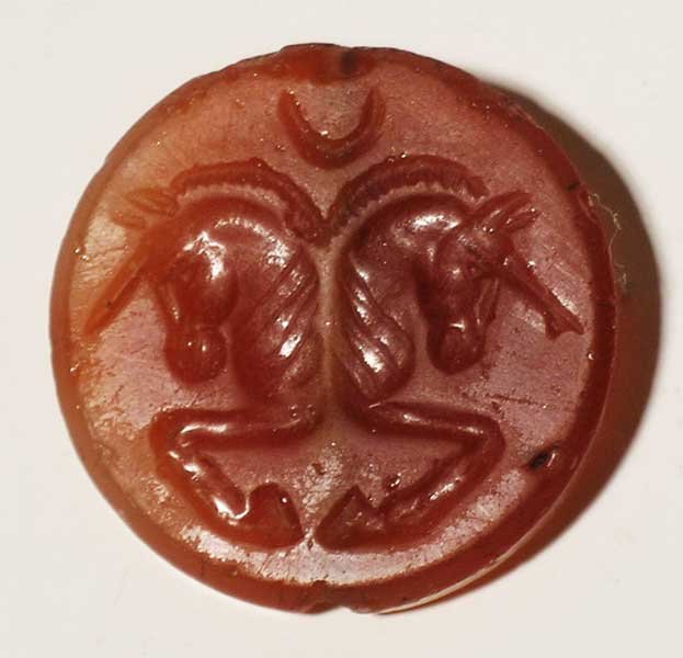 A choice Sassanian seal, c. 224 – 651 AD: A choice Sassanian seal, c. 224 – 651 AD. It is 1-1/8” in diameter and depicts a pair of conjoined horses. Carved from translucent carnelian and perforated laterally for suspension. Expected wear 
