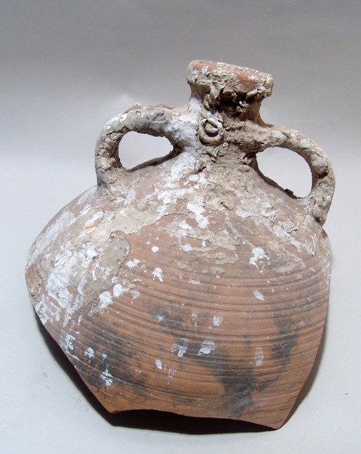 Upper portion of a Roman ceramic amphora: The upper portion of a Roman ceramic amphora, c. 1st - 3rd Century AD, the body with horizontal ribbing and a pair of loop handles to either side of the spout. H: 7" (17.8 cm); W: 10 1/4" (21.2 cm). S