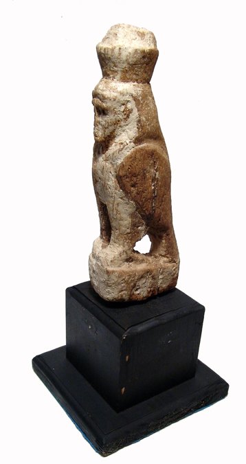 A wood figure of a human-headed falcon: A wood figure of a human-headed falcon, Late Period, c. 664 - 30 BC, wearing the double crown of Upper and Lower Egypt. H: 8 1/4" (25.9 cm). Some weathering, remains of white dressing. Mounted on larg