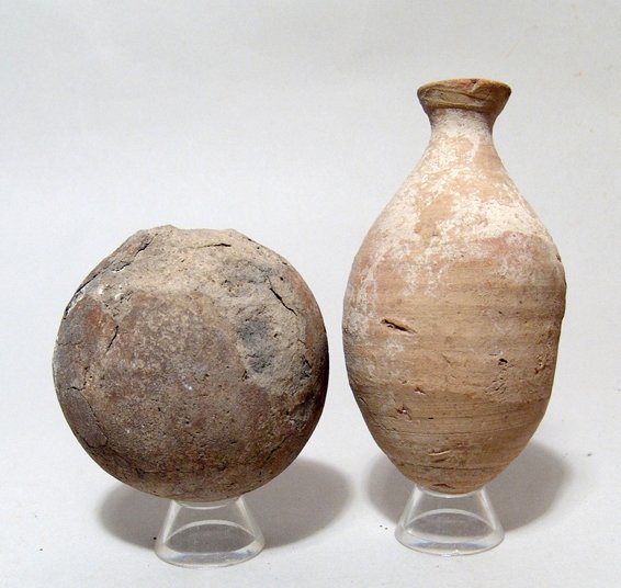 A pair of Egyptian ceramic vessels, Ex Lord Kitchener: A pair of Egyptian ceramic vessels, Late Period, c. 664 - 30 BC, the first an ovoid ceramic bottle with light horizontal ribbing visible on the body, the neck quite narrow a base and the rim flattened